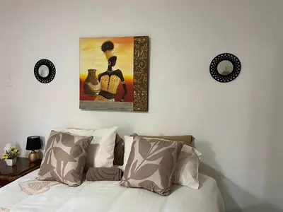a bedroom with a bed and a painting on the wall at The Fern Corner Guest House Unit 2 in Letaba