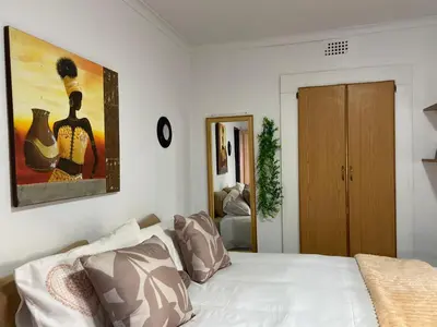 a bedroom with a bed with a painting on the wall at The Fern Corner Guest House Unit 2 in Letaba