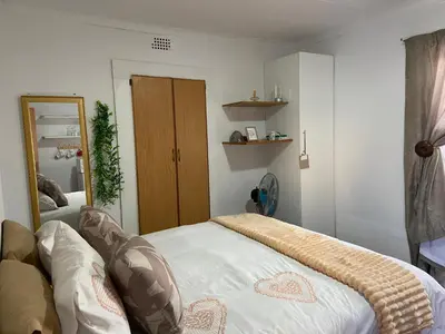 a bedroom with a bed and a large mirror at The Fern Corner Guest House Unit 2 in Letaba