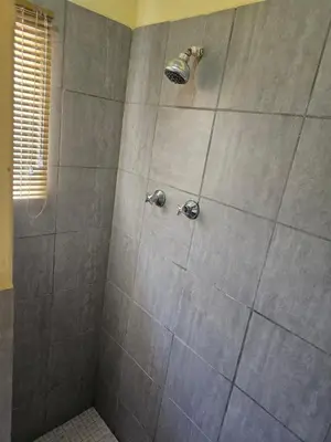 a shower with a large gray tiled shower at MATSOP Guesthouse in Bela-Bela