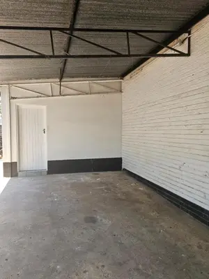 an empty parking garage with a white brick wall at MATSOP Guesthouse in Bela-Bela