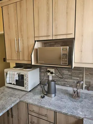 a kitchen with a microwave and a stove top oven at MATSOP Guesthouse in Bela-Bela
