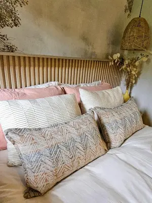 a bed with four pillows on top of it at Manchester Farmstay in White River