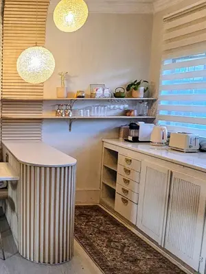 a kitchen with a counter and a table and lights at Manchester Farmstay in White River