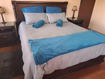 a bed with two blue pillows on top of it at Ithiliens Grace Guesthouse in Pretoria