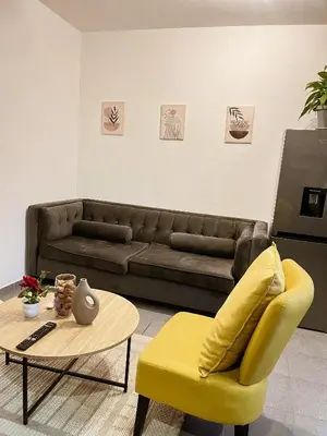 a living room with a couch and a yellow chair at Serenity suite in Midrand