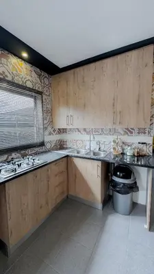 a large kitchen with wooden cabinets and a sink at Serenity suite in Midrand