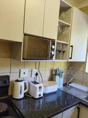 a kitchen with white appliances on a counter at The Crown in Nelspruit
