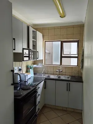 a kitchen with a sink and a stove top oven at The Crown in Nelspruit
