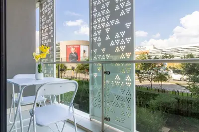 a balcony with a table and chairs and a window at Chic & Elegant at Ellipse in Midrand