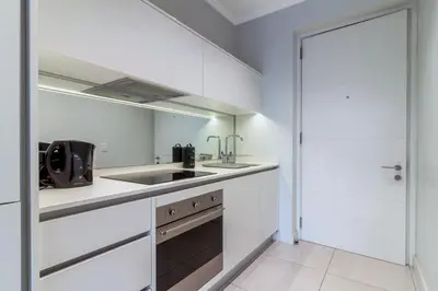 a white kitchen with a sink and a stove at Chic & Elegant at Ellipse in Midrand