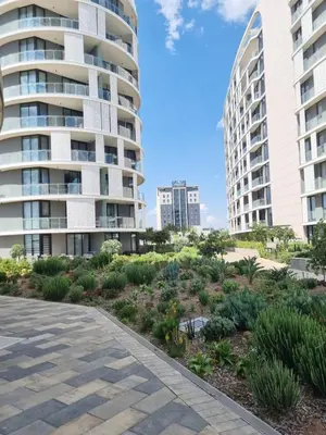two tall buildings and a garden with plants at Chic & Elegant at Ellipse in Midrand