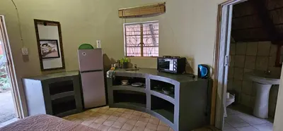 a small kitchen with a refrigerator and a sink at The Truck Rondawel in Marloth Park