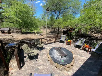 an outdoor patio with chairs and a fire pit at Milkwood Holiday Home in Marloth Park