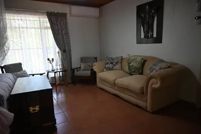 a living room with a couch and a table at Milkwood Holiday Home in Marloth Park