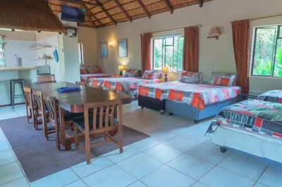 a living room with two beds and a table at Gallery Inn in Bela-Bela