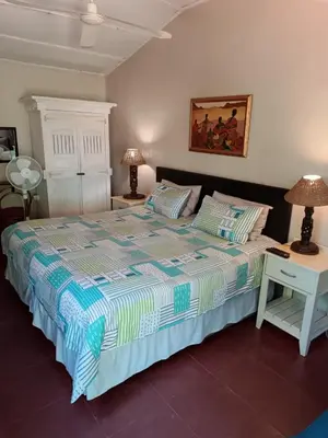 a bedroom with a bed and two tables with lamps at Gallery Inn in Bela-Bela