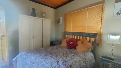a bedroom with a bed with pillows on it at Tranquility Guest House in Sabie