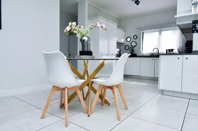 a kitchen with a table and two white chairs at The Waterfall Retreat in Midrand