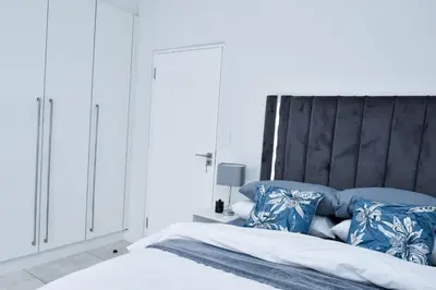 a bedroom with a bed with blue and white pillows at The Waterfall Retreat in Midrand