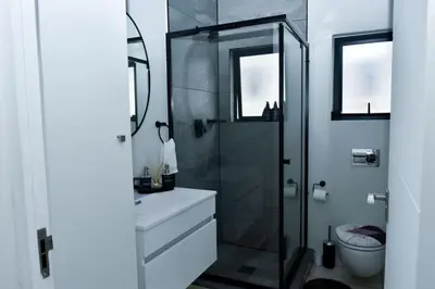 a bathroom with a shower and a sink and a toilet at The Waterfall Retreat in Midrand