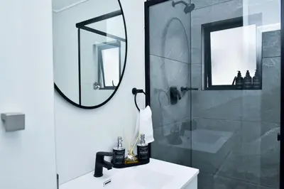 a bathroom with a sink and a mirror and a shower at The Waterfall Retreat in Midrand