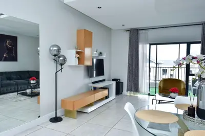 a living room with a couch and a table at The Waterfall Retreat in Midrand