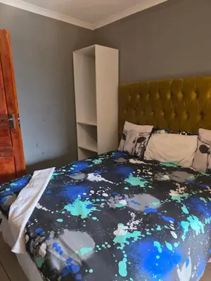 a bedroom with a bed with a blue comforter at EzekMary Res in Polokwane