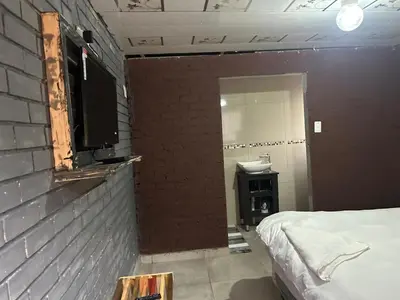 a room with a bed and a brick wall at EzekMary Res in Polokwane