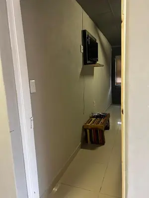 a hallway with a table and a tv on the wall at EzekMary Res in Polokwane
