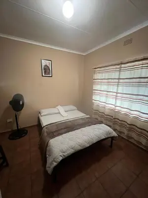 a bedroom with a bed and a window at Happy time accommodation in Phalaborwa