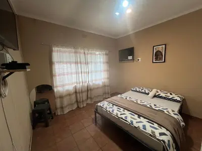 a small bedroom with a bed and a window at Happy time accommodation in Phalaborwa