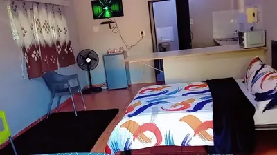 a bedroom with a bed and a desk with a fan at Happy time accommodation in Phalaborwa