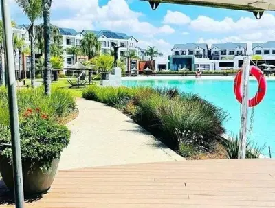 a swimming pool with a path next to some houses at The Blyde 2 and half Bedroom in Pretoria
