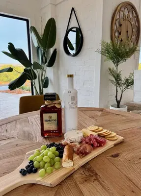 a table with a plate of food and a bottle of wine at Escape Pretoria East Luxury Villa in Tierpoort