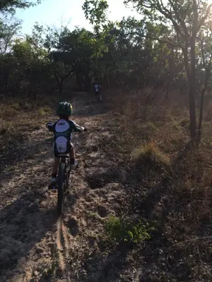 a child riding a bike on a dirt trail at Izintaba Private Game Reserve Waterberg in Vaalwater
