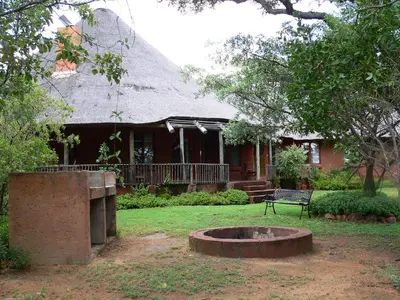 a house with a fire pit in front of it at Izintaba Private Game Reserve Waterberg in Vaalwater