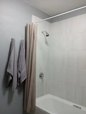 a bathroom with a tub and a shower curtain at Midrand Lodge in Midrand