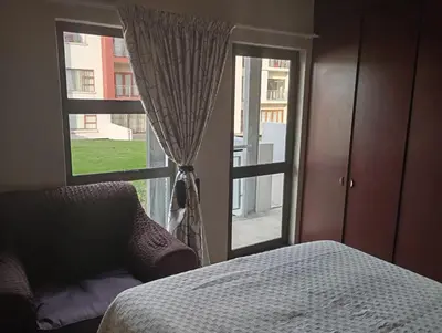 a bedroom with a bed and a large window at Midrand Lodge in Midrand