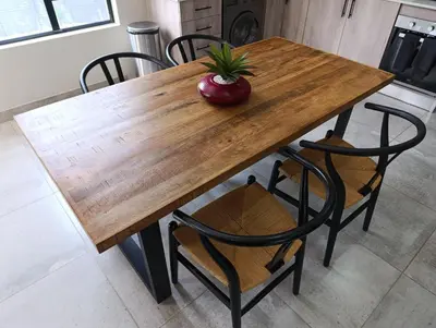 a wooden table with chairs and a vase on top at Joy Haven - Flat in Centurion