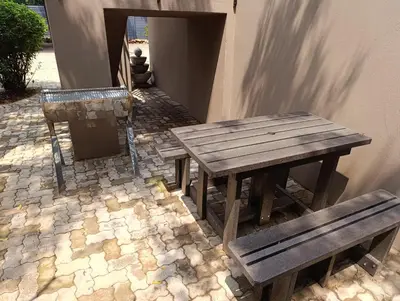 two wooden tables and benches sitting next to a building at Joy Haven - Flat in Centurion