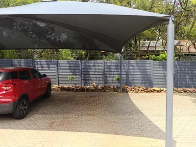 a red car parked under a black umbrella at Joy Haven - Flat in Centurion