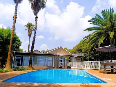 a house with a swimming pool and palm trees at Joy Haven - Flat in Centurion