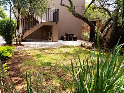 a patio with a table and a staircase in a yard at Joy Haven - Flat in Centurion