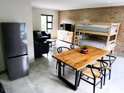 a living room with a table and a bunk bed at Joy Haven - Flat in Centurion