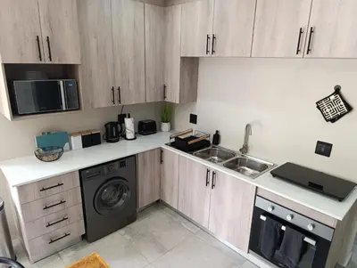 a kitchen with a sink and a washing machine at Joy Haven - Flat in Centurion