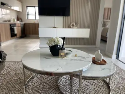 a white table with a vase of flowers on it at The blyde tranquil lagoon view escape in Pretoria