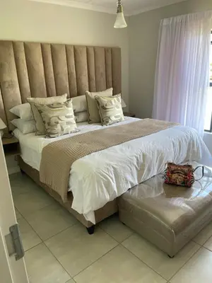 a large bed with a large headboard in a bedroom at The blyde tranquil lagoon view escape in Pretoria