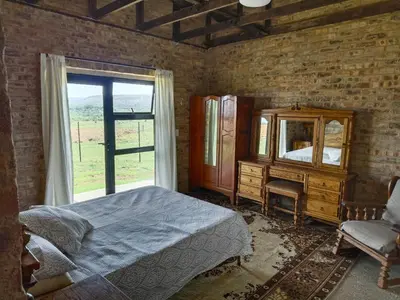 a bedroom with a bed and a mirror and a window at Olyfburg Herberg in Tierpoort