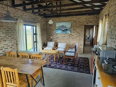a living room with a table and a couch at Olyfburg Herberg in Tierpoort